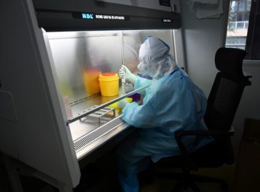 A technician processing samples in a lab at Chinese biotech company Coyote, before testing it in the Flash 20, a machine developed as a fast test for the COVID-19 coronavirus in Beijing, on Sept. 27, 2020. (Greg Baker/AFP via Getty Images)