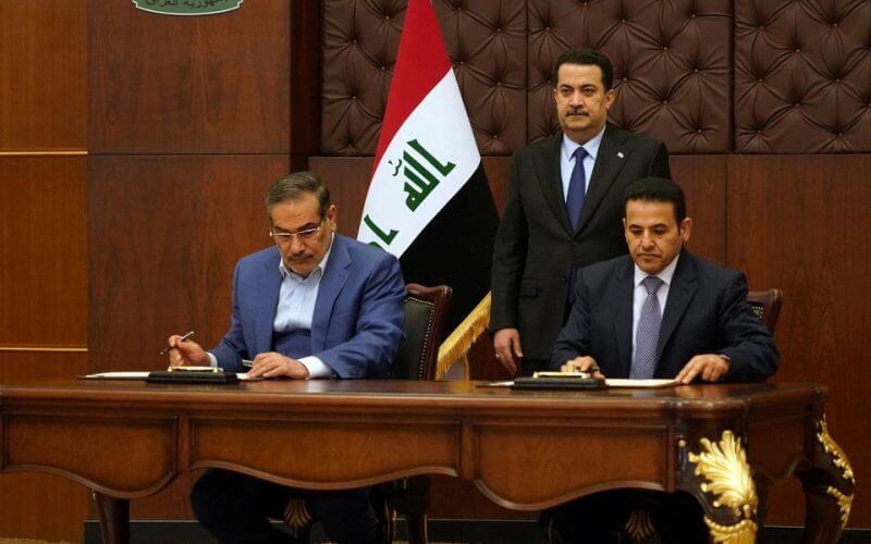 Iraqi Prime Minister Mohammed Shia al-Sudani looks on as Iraq's National Security Adviser Qasim al-Araji and Iran's Supreme National Security Council secretary Ali Shamkhani sign the security agreement that includes coordination in protecting the common borders between the two countries, in Baghdad, Iraq, March 19, 2023. Iraqi Prime Minister Media Office/Handout via REUTERS