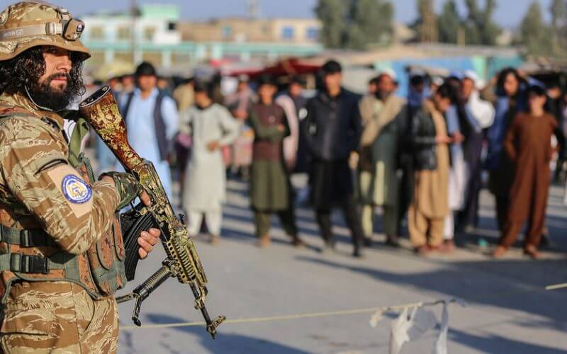 A Taliban security member stands guard along the Pakistan border in Nangarhar province, on Feb. 23. A new report said the Taliban are using fingerprint and gun records to track down those who helped the U.S. (Shafiullah Kakar/AFP via Getty Images)