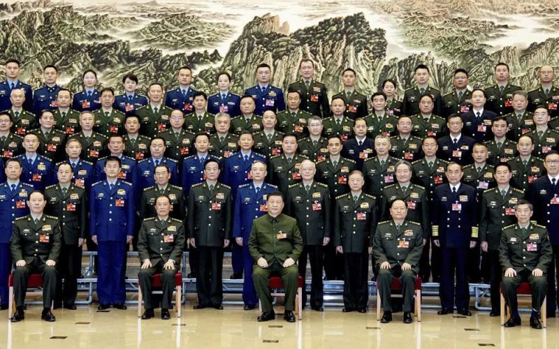 In this photo released by Xinhua News Agency, Chinese President Xi Jinping, bottom center, also general secretary of the Communist Party of China Central Committee and chairman of the Central Military Commission, poses for a group photo with deputies from the delegation of the People's Liberation Army (PLA) and the People's Armed Police Force before attending a plenary meeting of the delegation during the first session of the 14th National People's Congress (NPC) in Beijing, on Wednesday, March 8, 2023. AP