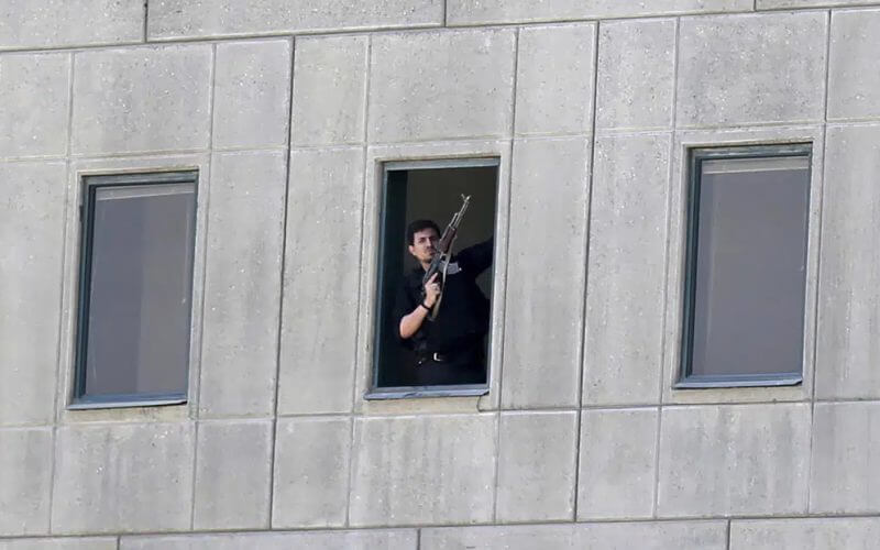 An armed man stands in a window of the parliament building during an attack by militants in Tehran, Iran on June 7, 2017. AP