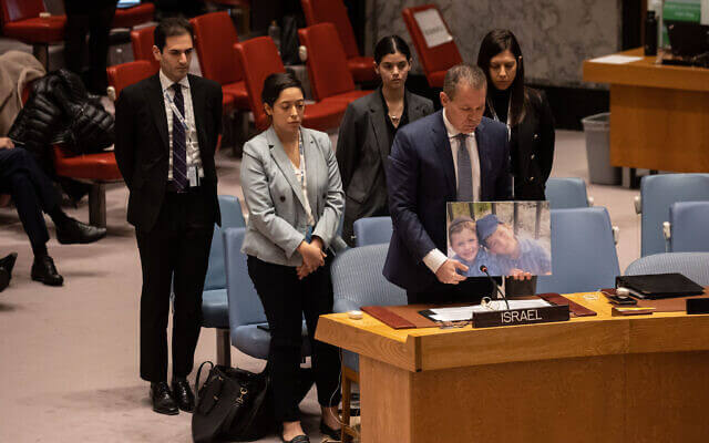 Israel's Ambassador to the United Nations Gilad Erdan (2R) and other Israeli delegates hold a moment of silence for terror victims brothers Yaakov and Asher Palley during the United Nations Security Council meeting on the situation in the Middle East, at the United Nations headquarters in New York City on February 20, 2023. (Yuki IWAMURA/AFP)