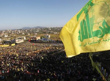 Supporters of Lebanon's Hezbollah leader Sayyed Hassan Nasrallah wave Hezbollah flags as they listen to him via a screen during a rally on the 7th anniversary of the end of Hezbollah's 2006 war with Israel, in Aita al-Shaab village in southern Lebanon, August 16, 2013. REUTERS/Ali Hashisho