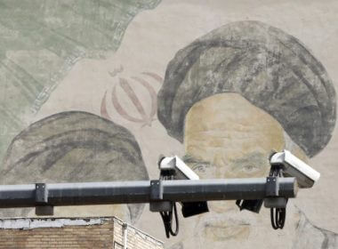 CCTV cameras are seen in front of an image of Iran’s late supreme leader, Ayatollah Ruhollah Khomeini, on a street in Tehran on April 10. (Abedin Taherkenareh/EPA-EFE/Shutterstock)