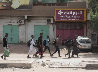 People walk past shuttered shops in Khartoum, Sudan, Monday, April 17, 2023. AP