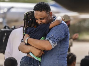 In this handout image provided by the UK Ministry of Defence, on Thursday, April 27, 2023, Violinist Othmano, right, hugs his daughter before boarding an RAF C-130, that will take them to Cyprus, at Wadi Seidna military airport, 22 kilometres (14 mi) north of Khartoum, Sudan. (PO Phot Aaron Hoare/UK Ministry of Defence via AP)