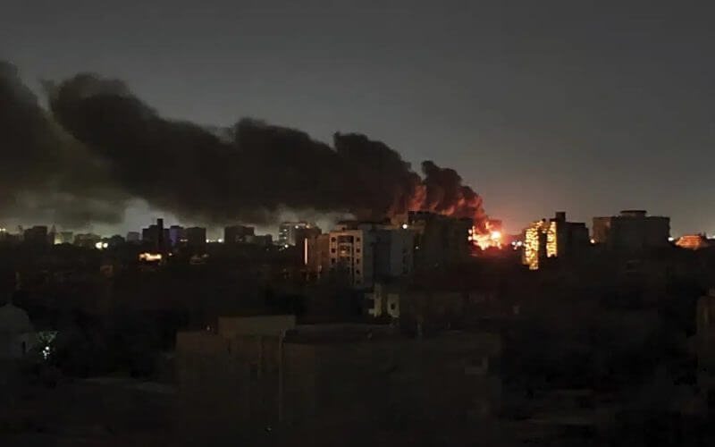 Smoke rises over the horizon as a fire burns after a strike in Khartoum, Sudan, Sunday, April 16, 2023. (AP Photo/Abdullah Moneim)