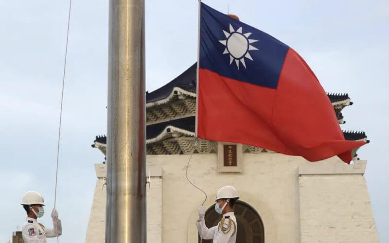 Two soldiers lower the national flag during the daily flag ceremony on Liberty Square of the Chiang Kai-shek Memorial Hall in Taipei, Taiwan, July 30, 2022. (AP Photo/Chiang Ying-ying, File)