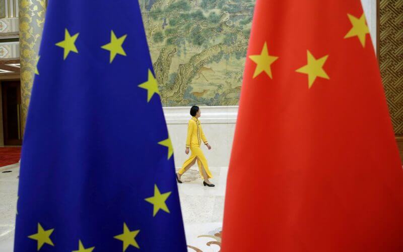 Photo d'archives: Une femme passe devant les drapeaux de l'UE et de la Chine avant le dialogue économique de haut niveau entre l'UE et la Chine au Diaoyutai State Guesthouse à Pékin, en Chine. /Photo prise le 25 juin 2018/REUTERS/Jason Lee