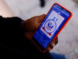 A migrant from Venezuela seeking asylum in the US uses his phone to access the CBP One application. Photograph: José Luis González/Reuters