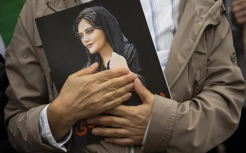 A portrait of Mahsa Amini is held during a rally calling for regime change in Iran following the death of Amini, a young woman who died after being arrested in Tehran by Iran's notorious "morality police," in Washington, on Oct. 1, 2022. (AP Photo/Cliff Owen, File)