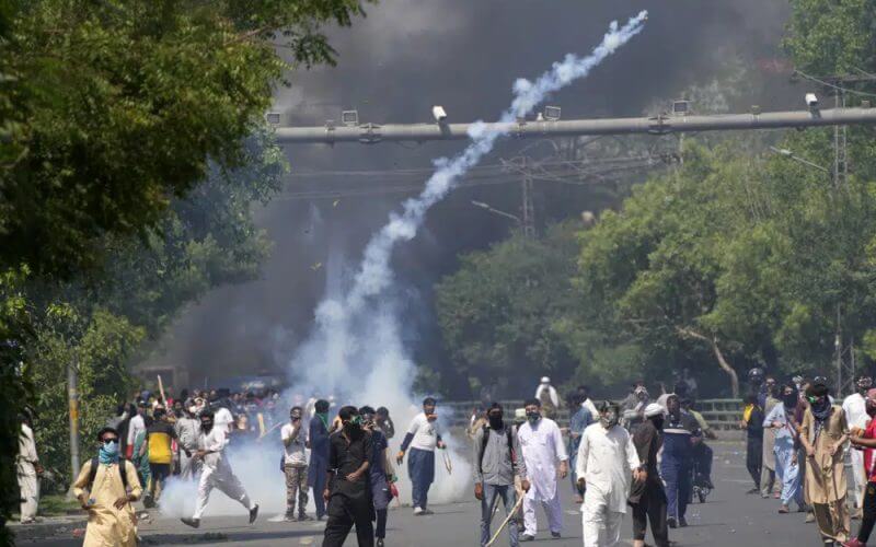 Police fire tear gas to disperse supporters of Pakistan's former Prime Minister Imran Khan protesting against the arrest of their leader, in Lahore, Pakistan, Wednesday, May 10, 2023. (AP Photo/K.M. Chaudary)