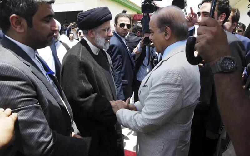 In this photo released by Pakistan Prime Minister's Office, Pakistan's Prime Minister Shahbaz Sharif, right, shakes hand with Iran's President Ebrahim Raisi during an inauguration of the Mand-Pishin border in Pishin, border of Pakistan-Iran, Thursday, May 18, 2023. (Pakistan Prime Minister Office via AP)