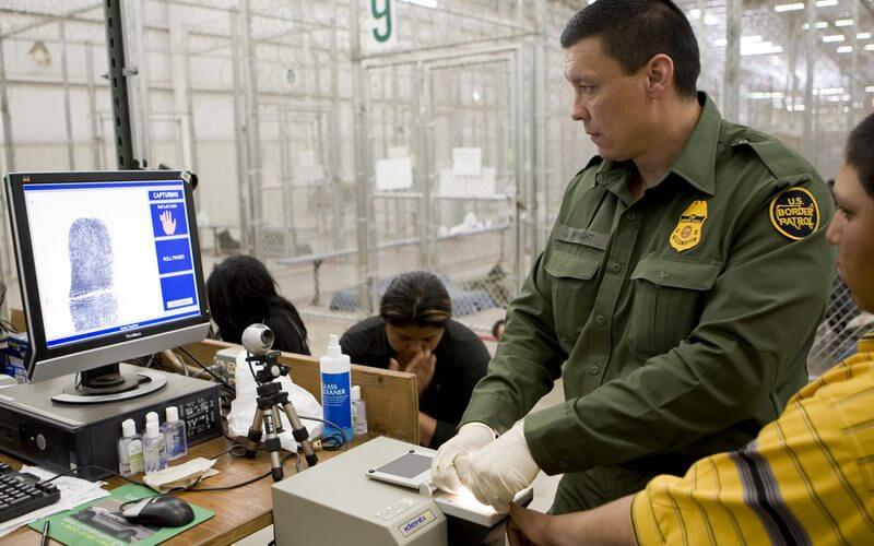 A Border Patrol agent processes individuals at a facility in Nogales, Arizona. (CBP)