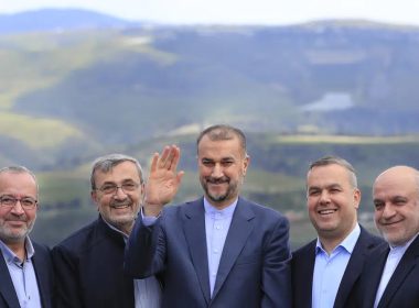 Iranian Foreign Minister Hossein Amirabdollahian, center, waves as he stands with Hezbollah members and lawmakers as the Israeli side seen in the background, during his visit to Iran park, in the village of Maroun el-Rass on the Lebanon-Israel border, south Lebanon, Friday, April 28, 2023. AP