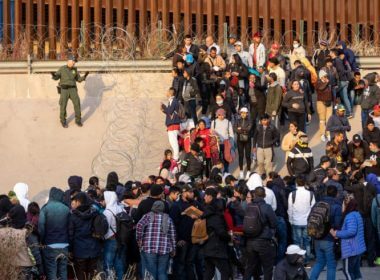 A U.S. border patrol agent talks to immigrants at the Texas-Mexico border / Getty Images