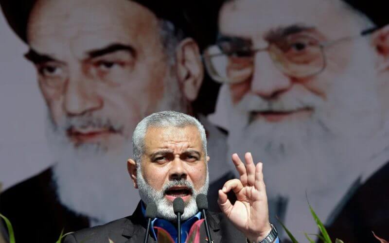 Visiting Hamas prime minister from Gaza, Ismail Haniyeh, gestures as he delivers his speech in front of portraits of late Iranian revolutionary founder Ayatollah Khomeini, left, and supreme leader Ayatollah Ali Khamenei, at a rally in Tehran, on Saturday, Feb. 11, 2012. AP