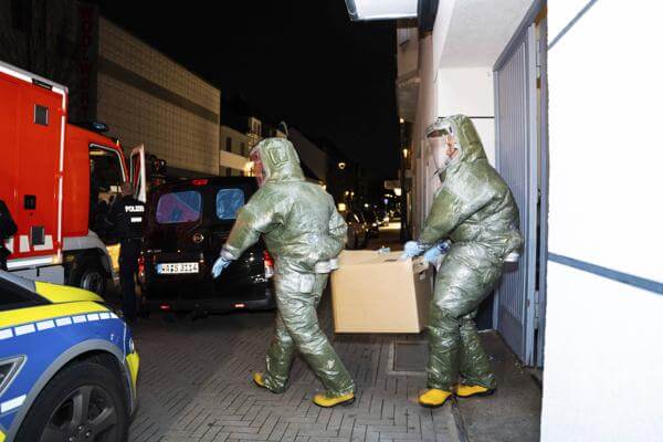 Men in protective suits carry a cardboard box out of a house in Castrop-Rauxel during an anti-terror operation on Jan. 8, 2023. (7aktuell.de, Marc Gruber/dpa via AP, File)