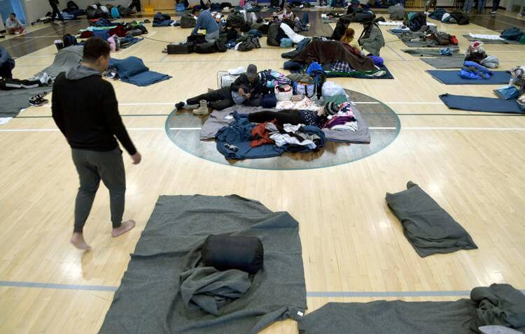 Migrants rest at a makeshift shelter in Denver on Friday, Jan. 6, 2023. Over the past month, nearly 4,000 immigrants, almost all Venezuelans, have arrived unannounced in the frigid city, with nowhere to stay and sometimes wearing T-shirts and flip-flops. AP Photo/Thomas Peipert