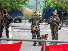 NATO Kosovo Force (KFOR) soldiers stand guard behind razor wire fence in the town of Zvecan, Kosovo, June 5, 2023. REUTERS