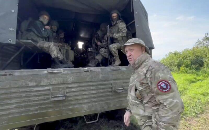 Founder of Wagner private mercenary group Yevgeny Prigozhin speaks with servicemen during withdrawal of his forces from Bakhmut and handing over their positions to regular Russian troops, in the course of Russia-Ukraine conflict in an unidentified location, Russian-controlled Ukraine. Press service of "Concord"/Handout via REUTERS