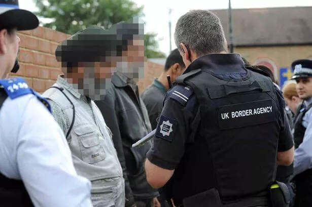 Illegal immigrants with members of the UK Border Agency. walesonline.co.uk