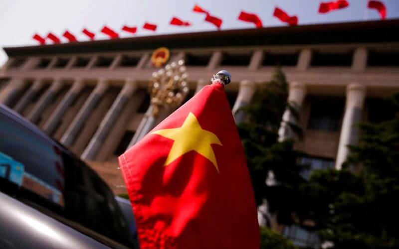 The Vietnamese national flag flies on a diplomatic car outside the Great Hall of the People in Beijing, China, May 12, 2017. REUTERS