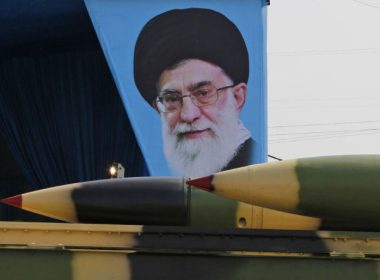 Iranian military truck carries missiles past portrait of Iranian Supreme Leader Ali Khamenei / Getty