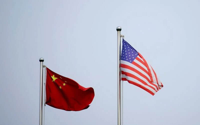 Chinese and U.S. flags flutter outside a company building in Shanghai, China April 14, 2021. REUTERS