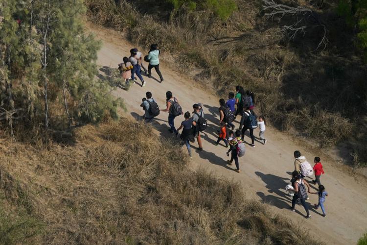 Migrants walk on a dirt road after crossing the U.S.-Mexico border, Tuesday, March 23, 2021, in Mission, Texas. Julio Cortez / AP Photo