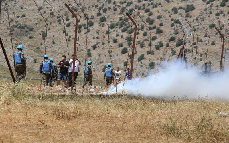 People gather to protest after an Israeli army bulldozer digs a ditch on the Lebanese border in Kafr Shuba region of southern Lebanon on June 11, 2023 [Ramiz Dallah - Anadolu Agency]