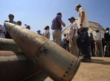 Activists and international delegations stand next to cluster bomb units, during a visit to a Lebanese military base at the opening of the Second Meeting of States Parties to the Convention on Cluster Munitions, in the southern town of Nabatiyeh, Lebanon, Sept. 12, 2011. (AP Photo/Mohammed Zaatari, File)