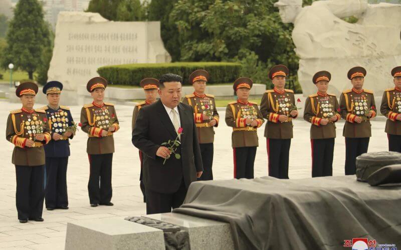 In this photo provided by the North Korean government, North Korean leader Kim Jong Un, foreground, prepares to offer a flower at a liberation war martyrs cemetery in Pyongyang, North Korea Tuesday, July 25, 2023, on the occasion of the 70th anniversary of the armistice that halted fighting in the 1950-53 Korean War. (Korean Central News Agency/Korea News Service/AP)