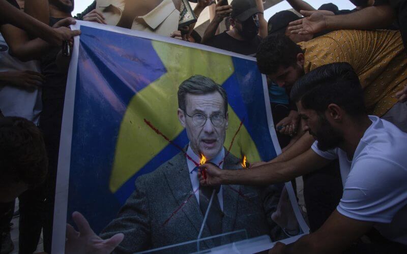 Iraqis burns the picture of Sweden's prime Ulf Kristersson, during a protest in Tahrir Square, Thursday، July 20, 2023 in Baghdad, Iraq. (AP Photo/Adil AL-Khazali)
