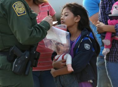 Stefany Marjorie, 8, watches as a U.S. Border Patrol agent records family information on July 24, 2014 in Mission, Texas. (Photo by John Moore/Getty Images)