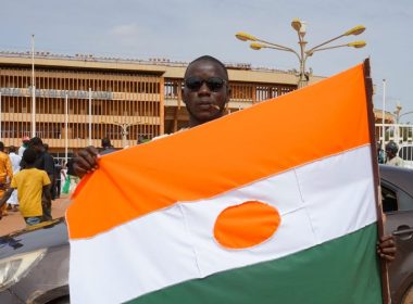 A man displays a Niger flag on his way to a rally in a stadium in Niamey, Niger, on Sunday. Photo by Issifou Djibo/EPA-EFE