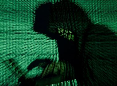 A man holds a laptop computer as cyber code is projected on him in this illustration picture taken on May 13, 2017. REUTERS