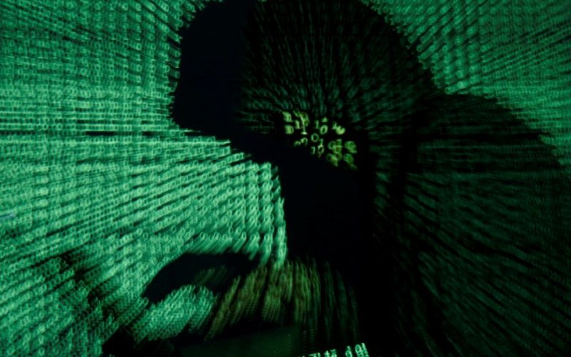 A man holds a laptop computer as cyber code is projected on him in this illustration picture taken on May 13, 2017. REUTERS