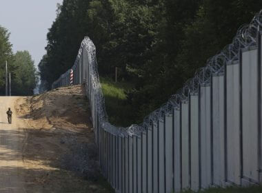 A Polish border guard patrols the area of a built metal wall on the border between Poland and Belarus, near Kuznice, Poland, on June 30, 2022. AP