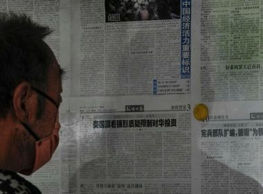 A man reads a Global Times newspaper carrying an article, center, that reads "U.S. has resisted strong skepticism about restricting investment in China" posted on a public newspaper bulletin board in Beijing, Thursday, Aug. 10, 2023. (AP Photo/Andy Wong)