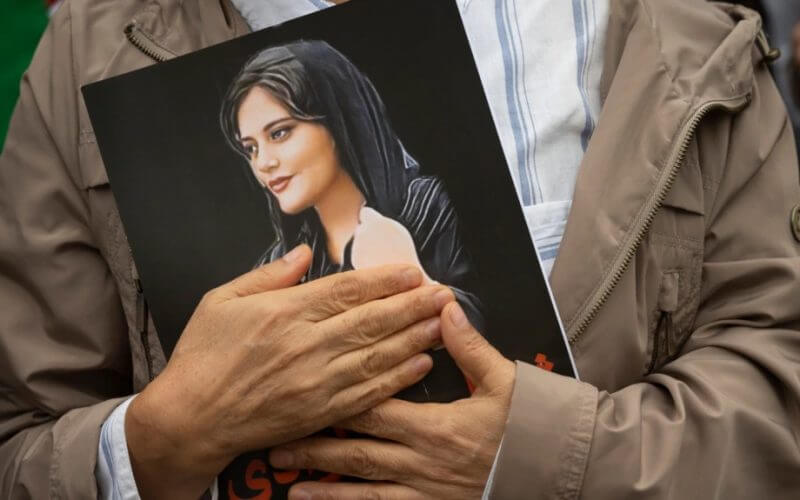 A person holds a portrait of Mahsa Amini during a rally in Washington on Oct. 1, 2022. AP