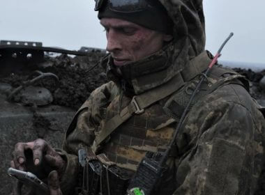 A Ukrainian soldier uses his mobile phone on front line near Bakhmut, in Ukraine's Donetsk region, partially occupied by Russian forces, March 11, 2023. AFP