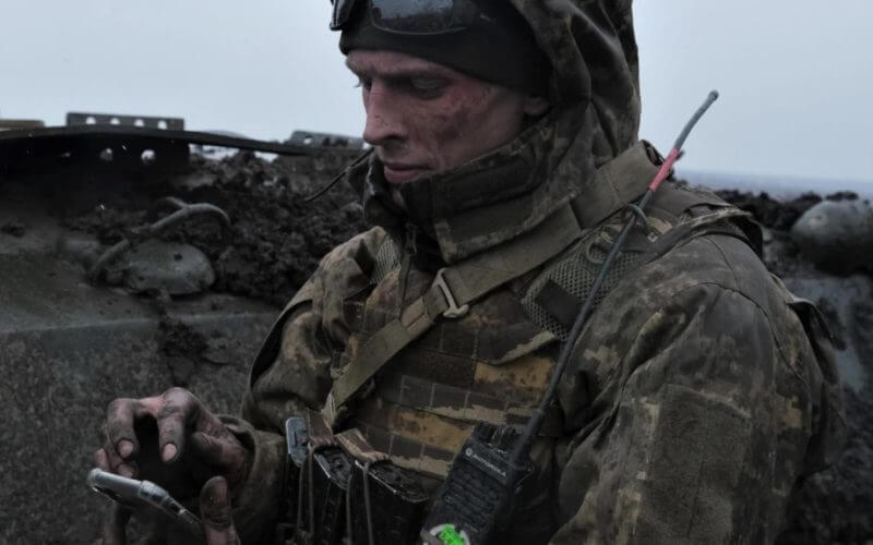 A Ukrainian soldier uses his mobile phone on front line near Bakhmut, in Ukraine's Donetsk region, partially occupied by Russian forces, March 11, 2023. AFP