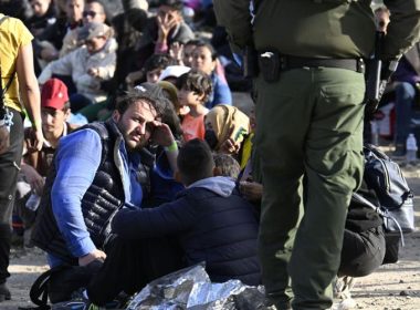 Asylum seekers wait between the double fence on U.S. soil along the U.S.-Mexico border near Tijuana, Mexico on Monday, May 8, 2023, in San Diego. The migrants wait between the fences to be processed by U.S. Border Patrol agents. Denis Poroy | AP