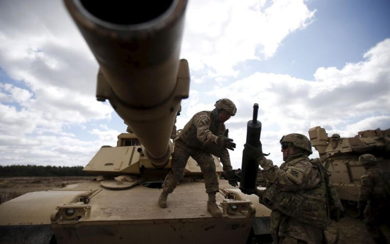 Members of the U.S. 2nd Battalion, 7th Infantry Regiment, 1st Brigade Combat Team, 3rd Infantry Division get ammunition to the Abrams tank during an exercise at Mielno range near Drawsko-Pomorskie April 16, 2015. REUTERS