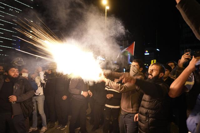 People throw fireworks toward the Israeli consulate as they protest to show solidarity with Palestinians, in Istanbul, Turkey, Wednesday, Oct. 18, 2023. Khalil Hamra | AP