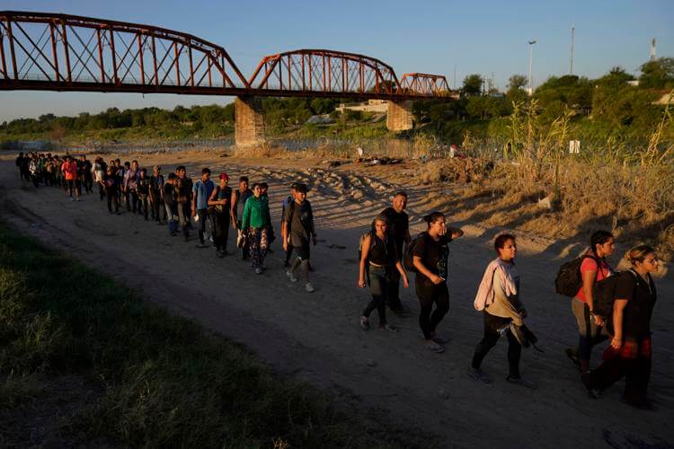 Migrants who crossed the Rio Grande and entered the U.S. from Mexico are lined up for processing by U.S. Customs and Border Protection, Sept. 23, 2023, in Eagle Pass, Texas. Eric Gay | AP
