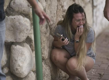 Israelis take cover from incoming rocket fire from the Gaza Strip in Ashkelon, Israel, on Oct. 11, 2023. (AP Photo/Leo Correa)