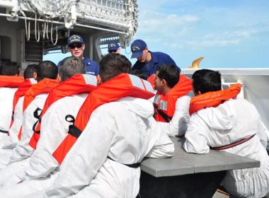 A crew member from the Coast Guard Cutter Diligence talks to Cuban migrants onboard Cutter Diligence Feb. 10, 2016 off the coast of Key West, Fla. The migrants were transferred from the Diligence to the Coast Guard Cutter Charles David Jr. for repatriation. Petty Officer 1st Class Melissa Leake / U.S. Coast Guard photo