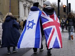 Two protesters wrapped in the flags of Israel and Britain walk in London during a march against anti-Semitism (AP Photo/Alberto Pezzali)